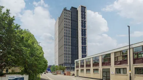 Corstorphine & Wright A computer-generated image shows a tall grey tower block in an industrial area.