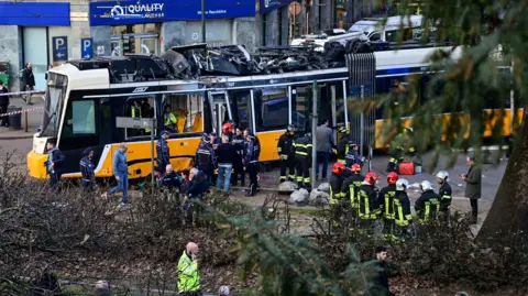 Emergency services stand around crashed tram
