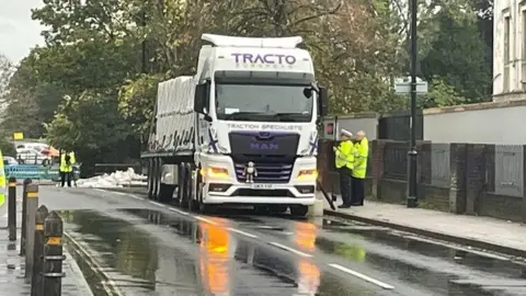 The lorry pulled over at the side of the road with police officers stood next to it in high vis