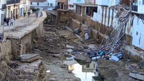 AFP via Getty Images Debris lies in the river next to destroyed houses in Chiva, in the region of Valencia, eastern Spain, in the aftermath of catastrophic deadly floods on November 19, 2024