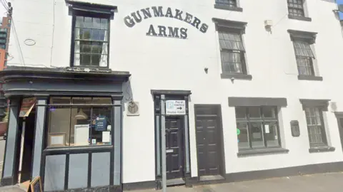 Google The white-painted pub has black window frames and its entrance on the left. Its name appeared on the right hand side of the building which sits on the corner of a street. 