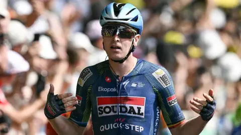 Tim Merlier celebrates winning stage seven
