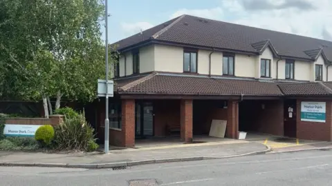 A care home building which is two-storey and red brick.