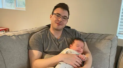 Grayson Chester Grayson Chester with his 2-month-old baby sleeping in his arms