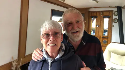 John Devine/BBC Val and Brian Timperley on their narrowboat in Ely