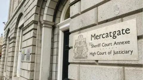 A general view of the court building in Aberdeen. It is a grey stone building with a court sign on the right-hand side of the picture. 