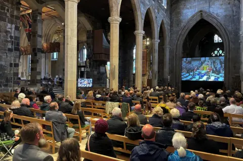 PA Media People watching in church