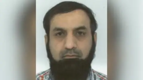 Mohammad Siddiqui mugshot - He has brown combed-over hair and a long brown beard.