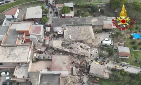 Vigili del Fuoco Taken from a drone, two large holes can be seen in a roof lying on top of rubble