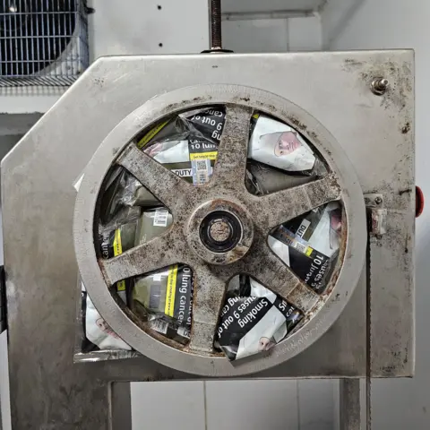 Northumbria Police Packets of illegal tobacco wedged underneath a metal wheel on an item of machinery. 