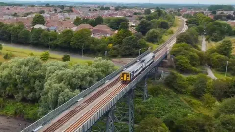 A train crosses a bridge over a river