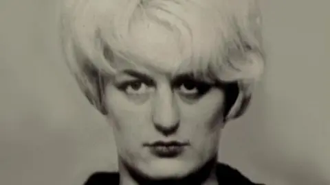 PA Media A black and white police mugshot of Myra Hindley, a woman with large white hair