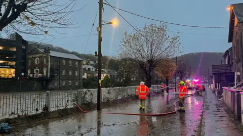 PA Firefighters pumping flood waters connected  Sion Street, Pontypridd, Wales.