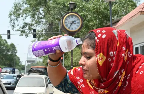 Getty Images A young girl washes her face as increasing temperature during hot weather, on May 18, 2024 in New Delhi, India.