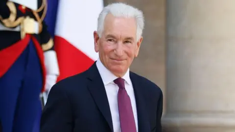 Charles Kushner smiles while leaving the Elysee Palace