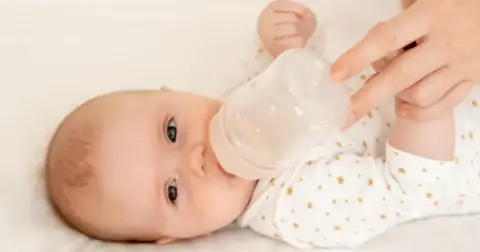 A baby with a bottle 