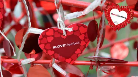 North Kesteven District Council A close up of a tag that says Love Sleaford on it is fixed to the structure with string.