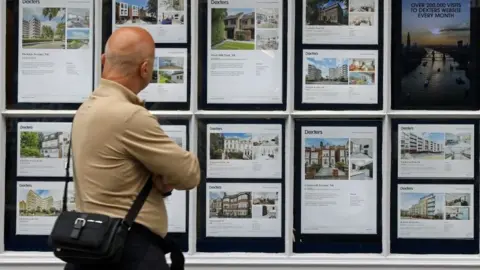 Getty Images A man looks at houses for sale