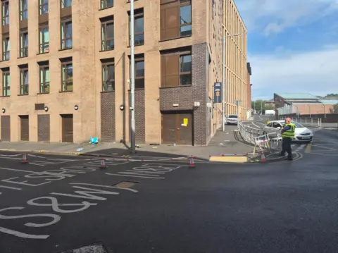 A police cordon blocks off a path and part of Union Road