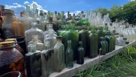 Zoe Brown Close up on the clear end green bottles