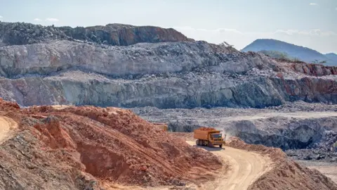 Bloomberg via Getty Images A truck moves material along a twisting red dirt road during mining operations at the Bikita Minerals lithium mine site in Bikita, Zimbabwe - 2024.