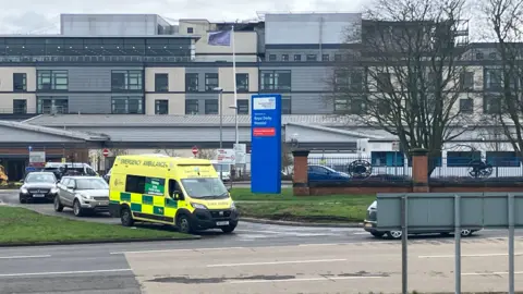 A general view of Royal Derby Hospital with an ambulance leaving the site.