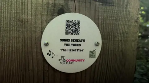 QR code attached to a wooden marker post