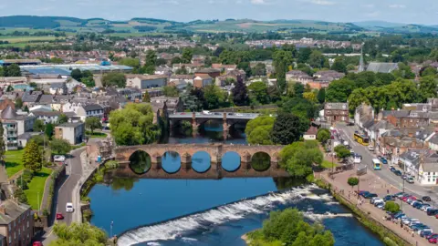 An aerial view of Dumfries with bridges across the River Nith and groups of houses on both sides