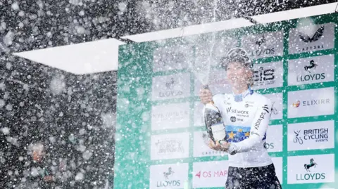 PA Media Lorena Wiebes celebrates on the podium after her win