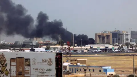 Getty Images Heavy smoke billows above buildings in the vicinity of the Khartoum airport on April 15, 2023
