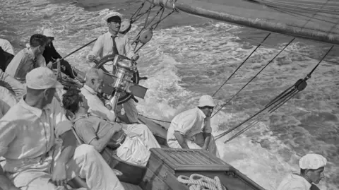 Getty Images A black and white archive picture of the crew of racing yacht Candida pictured at sea off Cowes in 1935