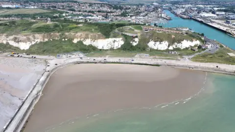 Eddie Mitchell A sandy beach is seen from above. 