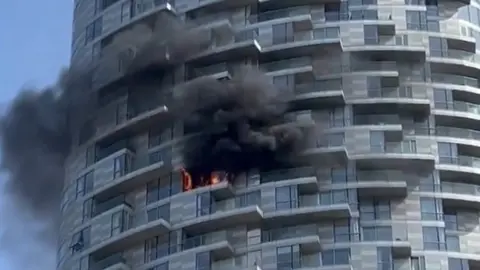  @JohnWickMG/PA The scene of a fire at a multi-storey tower block at New Providence Wharf in London