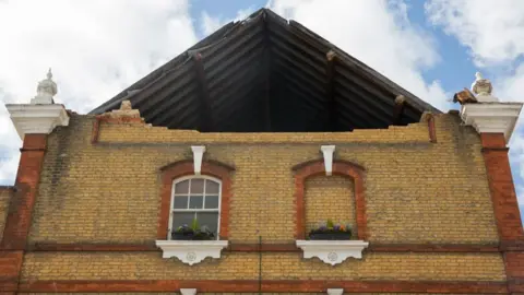 Getty Images A picture shows the hole in the roof support of a pub.