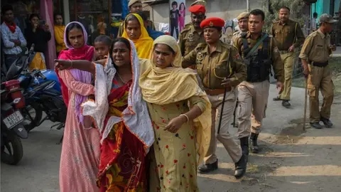 Getty Images Women react after police arrest their relatives near Mayong police station in Morigaon district on 4 February