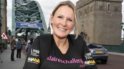 BBC Claire is stood nearby to a bridge smiling into the camera during the Great North Run
