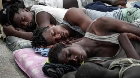 AFP Illegal immigrants are seen sleeping at a detention centre in Libya