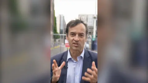 Political correspondent Damian Grammaticas wearing a blue suit with London in the background.