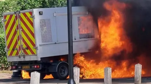 A litter collection van on fire.