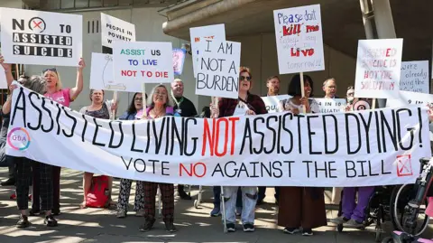 Getty Images Opponents on the vote on the plans to legalise assisted dying demonstrate outside the Scottish Parliament to show support against Stage 1 of Scotland’s assisted dying bill 