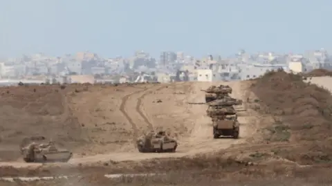 Reuters Israeli armoured vehicles maneuver at an area inside the northern Gaza Strip, as seen from the border with Gaza in southern Israel, 06 October 2024