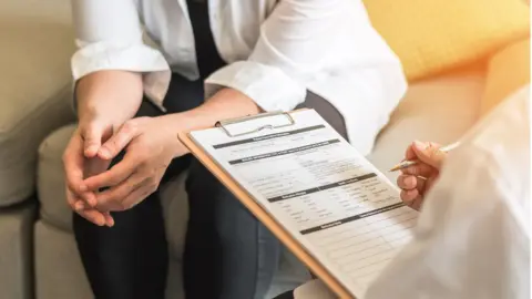 Getty Images Patient talking to a doctor about symptoms