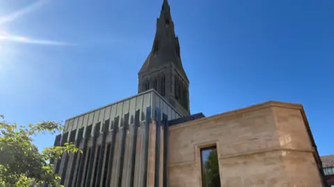 The copper-roofed extension in front of the cathedral spire