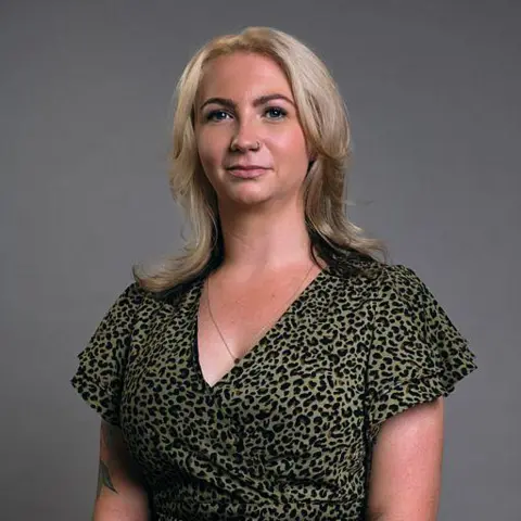BBC Scotland Jenni, a young woman with shoulder-length, blonde hair, looks at the camera. She is wearing a green and black animal-print top. 