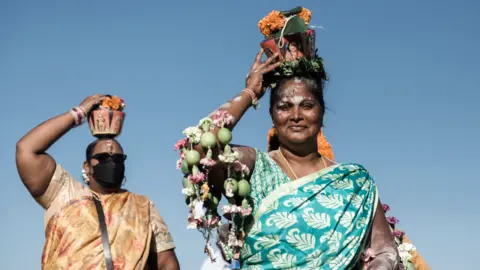 AFP Two Hindu worshippers with milk pots on their heads at the Ferndale grounds near the Suria Narayan temple in Phoenix township, South Africa - Tuesday 18 January 2022