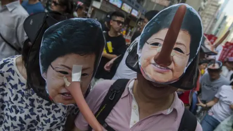 EPA Protesters wearing masks of Hong Kong Chief Executive Carrie Lam, complete with a long "Pinocchio" noses to suggest lying, march through the streets during the annual pro-democracy march, Wan Chai, Hong Kong, China, 01 July 2018.