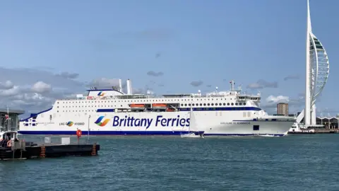Brittany Ferries A large, white vehicle ferry passes Portsmouth's Spinnaker Tower on its way to France