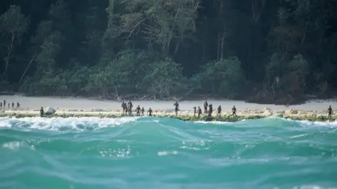 Christian Caron - Creative Commons A-NC-SA The Sentinelese stand guard on an island beach in 2005