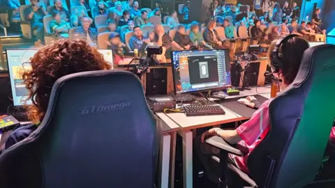 Confetti Arrows Three players participating in a esports game for spectators.