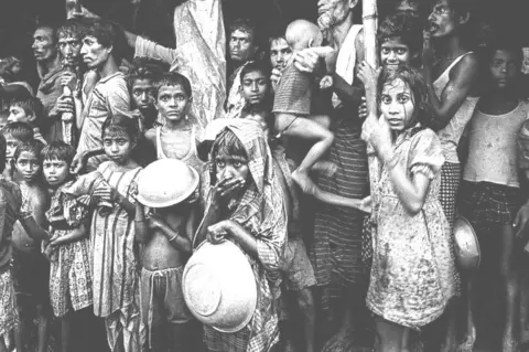 Shahidul Alam Children and adults sheltering from rain, flood victims in Mymensingh, Bangladesh. 1988.